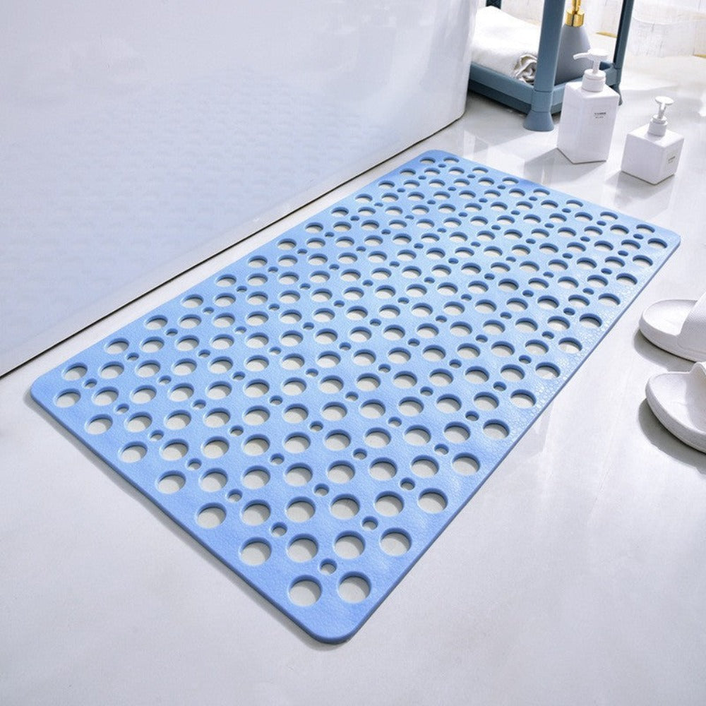 Blue antibacterial suction shower mat with non-slip drainage holes in a bathroom


